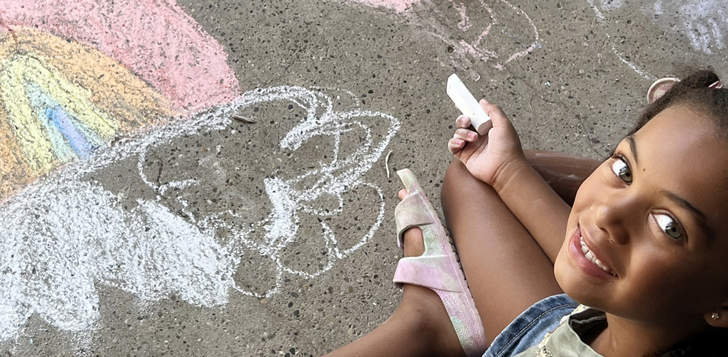Pattengill student drawing on sidewalk during "Chalk The Walk"