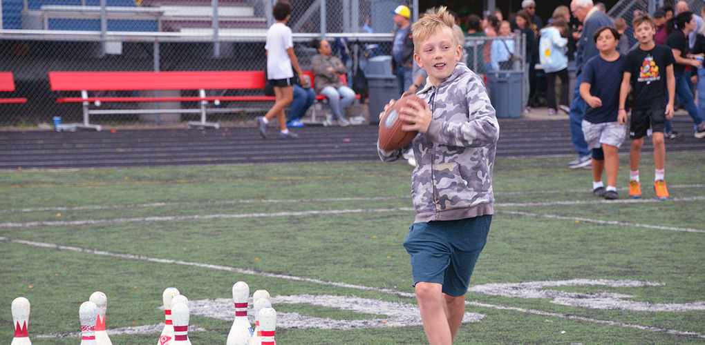 Anderson student tossing football at Viking Fest