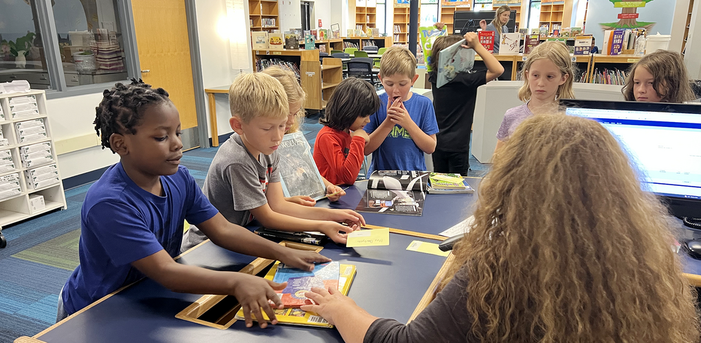 Students checking out books in media center during 2nd week of school