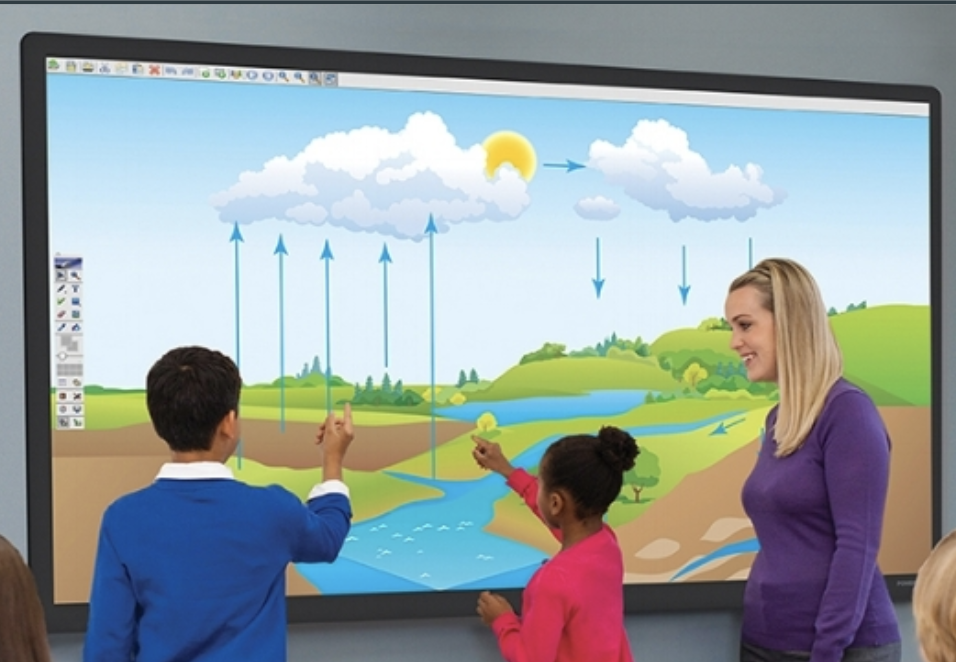 Two students standing at an interactive panel with a teacher working on a lesson